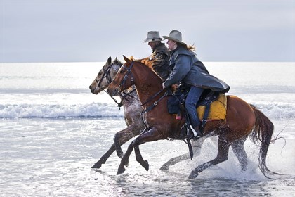 Jocelyn and Robbins Island Wagyu owner and manager John Hammond gallop through the shallows. © John Wiseman Photography
